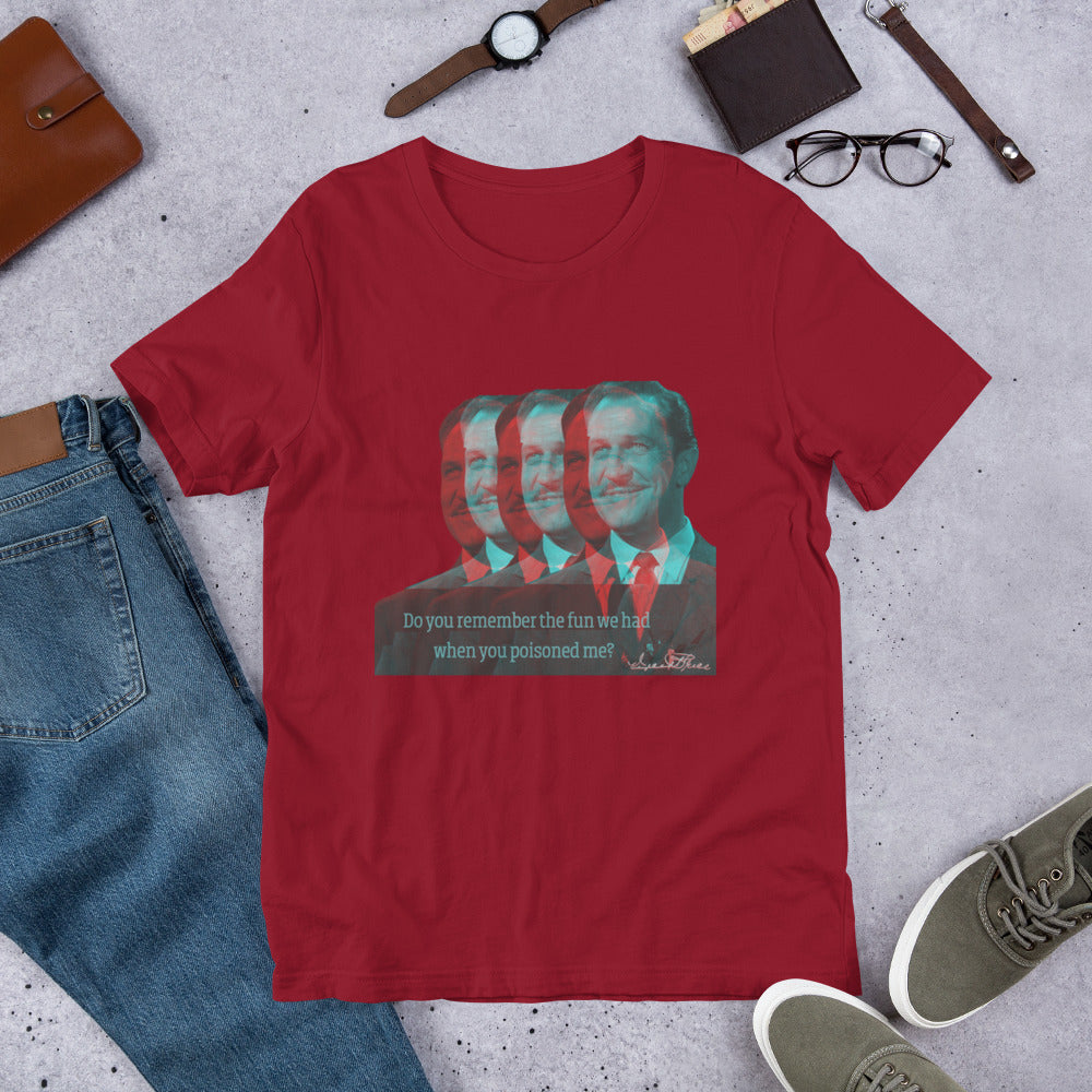 A red t-shirt with a graphic print of a person's face, resembling Vincent Price, in a casual setting with jeans, a leather jacket, and a pair of eyewear.